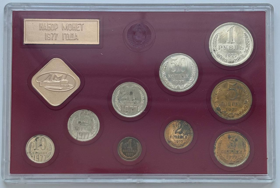 Годовой набор монет улучшенного качества Госбанка СССР 1977 г. ЛМД: 1 рубль, 50 копеек, 20 копеек, 15 копеек, 10 копеек. Медно-никелевый сплав. 5 копеек, 3 копейки, 2 копейки, 1 копейка. Медно-цинковый сплав. Жесткий пластик, пластмассовый трафарет красного цвета, с ромбовидным жетоном ЛМД и годовой плашкой из алюминия. Сохранность почти отличная, патина, пятна. Петров, Федорин №№ 345, 346, 348, 350, 351, 354, 356, 361, 364. Набор вложен в оригинальную картонную коробку оливкового цвета.