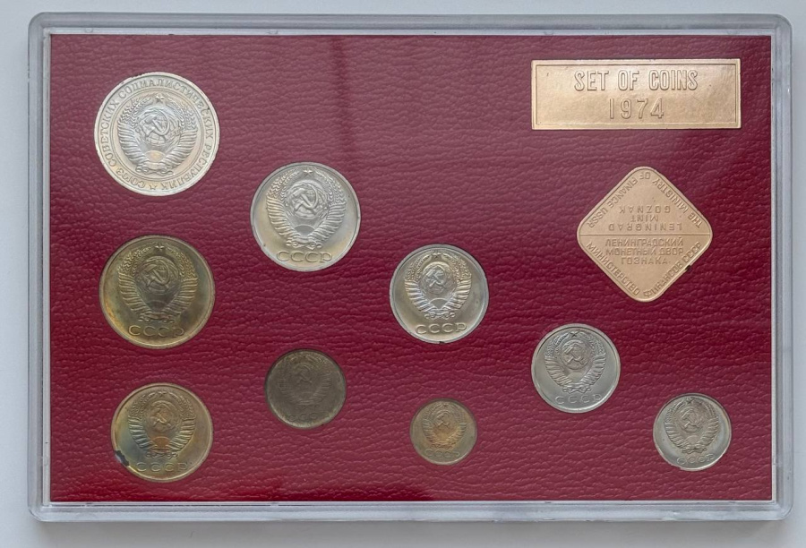 Годовой набор монет улучшенного качества Госбанка СССР 1974 г. ЛМД: 1 рубль, 50 копеек, 20 копеек, 15 копеек, 10 копеек. Медно-никелевый сплав. 5 копеек, 3 копейки, 2 копейки, 1 копейка. Медно-цинковый сплав. Жесткий пластик, ледериновый трафарет красного цвета, с ромбовидным жетоном ЛМД и годовой плашкой из алюминия. В состав набора входит редкая «перепутка» 20 копеек с аверсом 3 копеек-ленты герба сильно вогнутые. Сохранность отличная. Петров, Федорин №№ 306, 307, 309 (Р04), 310, 311, 312, 313, 317, 319. Набор вложен в оригинальную картонную коробку оливкового цвета. 
